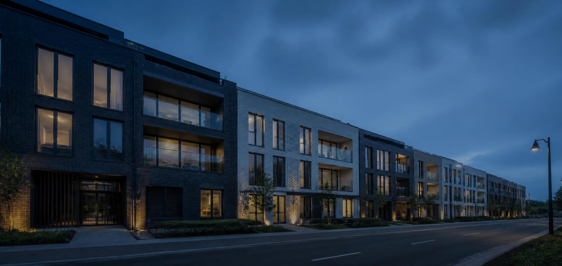 Rij moderne appartementsgebouwen bij valavond